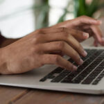 An image of a person who is working on a laptop for the article "Advantages and Disadvantages of Grammarly"