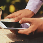 An image of two hands holding a smartphone for the article "Difference Between IPS LCD and PLS LCD"