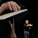 An image of Steve Jobs during one of his keynote presentations for the article "Steve Jobs: Leadership and Management Style"