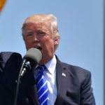 Donald Trump raising his fist during a public appearance for the article "Inauguration Of Donald Trump: Why Billionaires Are Donating?"