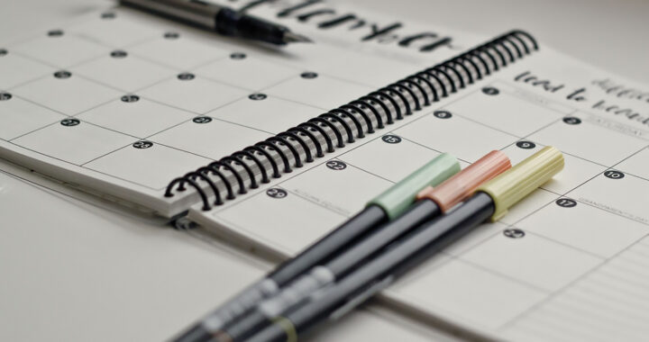 Pens placed on top of a planner for the article "Insights From Science: Why New Year’s Resolutions Fail"