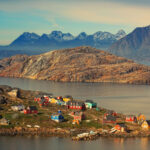 An image showing the landscape of Kulusuk municipality with some houses in Greenland for the article "Who Exactly Owns Greenland? Can It Be Readily Annexed?"