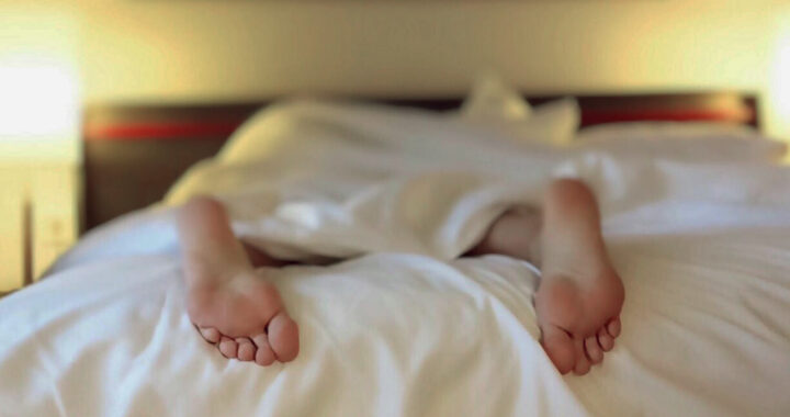 Feet of a man in bed for the article "Labor Force Participation Among U.S. Men Declining"